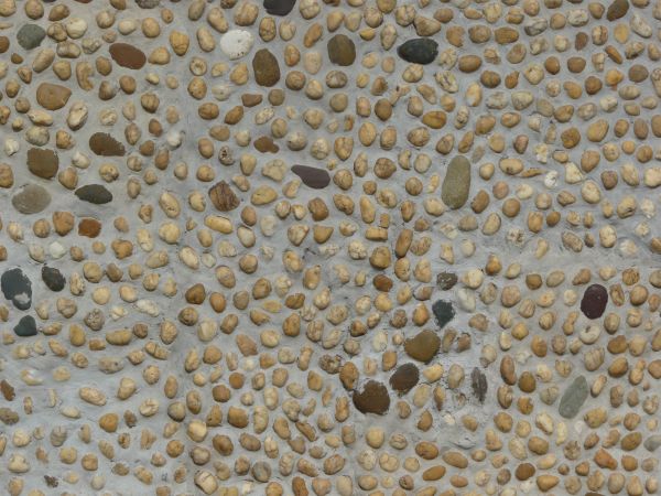Small pebbles set in concrete wall texture.